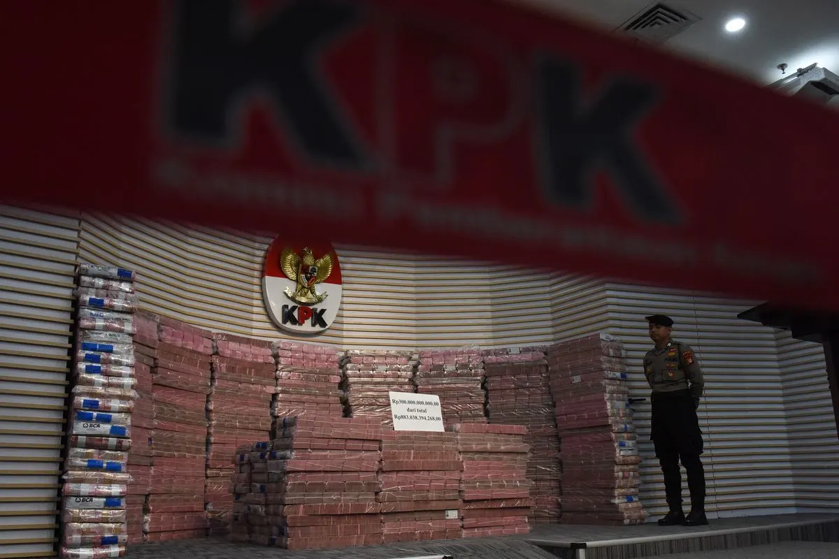 Polisi menjaga tumpukan uang yang merupakan barang rampasan negara saat acara penyerahan barang rampasan negara dari KPK kepada PT TASPEN di Gedung Merah Putih KPK, Jakarta, Kamis (20/11/2025). PT TASPEN (Persero) menerima secara resmi pengembalian kerugian keuangan negara berupa Unit Penyertaan Reksa Dana Insight Tunas Bangsa Balanced Fund 2 (I-Next G2) dengan jumlah unit 996.694.959,5143 senilai Rp883.038.394.268 dari KPK, di mana dana restitusi tersebut merupakan hasil tindak lanjut proses hu
